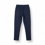 Navy blue tracksuit pants with a white logo on a light gray background