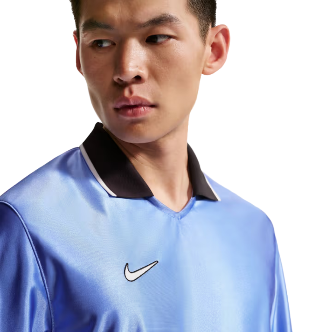 A close-up of a man wearing a light blue Nike athletic jersey with a black collar and a white embroidered swoosh logo on the chest, set against a plain white background.