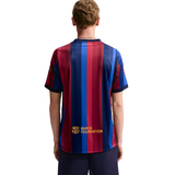 Person wearing a red and blue striped sports jersey with 'Barca Foundation' text on a white background