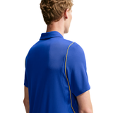 A man viewed from the back wearing a royal blue short-sleeve polo shirt with a thin yellow piping detail along the shoulder seam, set against a plain white background.