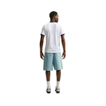 A man viewed from behind wearing a white short-sleeve t-shirt with navy blue trim, light blue denim shorts, white socks, and sneakers, set against a plain white background.