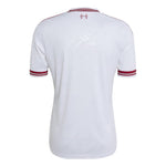 White short-sleeve soccer jersey shown from the back, featuring thin red stripes on the collar and sleeve cuffs, and a small red crest centered below the neckline.
