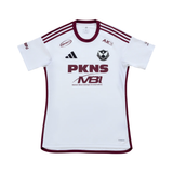 A white short-sleeve soccer jersey with maroon trim, featuring the PKNS and MBI logos on the front, the Adidas logo, and the AKS logo. The jersey is displayed flat against a solid white background.
