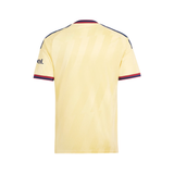 A pale yellow short-sleeve soccer jersey shown from the back, featuring navy and red striped trim on the collar and sleeve cuffs, with a partial black 'el.' logo on the right sleeve.