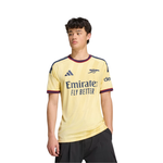 A young man wearing a pale yellow Arsenal football jersey with navy and burgundy trim, featuring the Emirates Fly Better sponsor logo and Adidas branding, set against a plain white background.