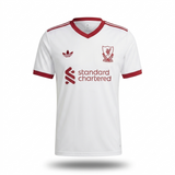 White Adidas Liverpool football jersey with red trim, featuring the Liverpool club crest, Adidas trefoil logo, and Standard Chartered sponsor logo.